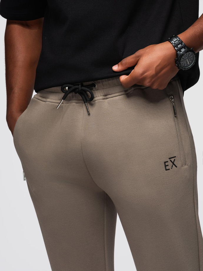 Spodnie dresowe męskie ze ściągaczami w nogawkach i gumowym nadrukiem – popielate V3 OM-PASK-0223