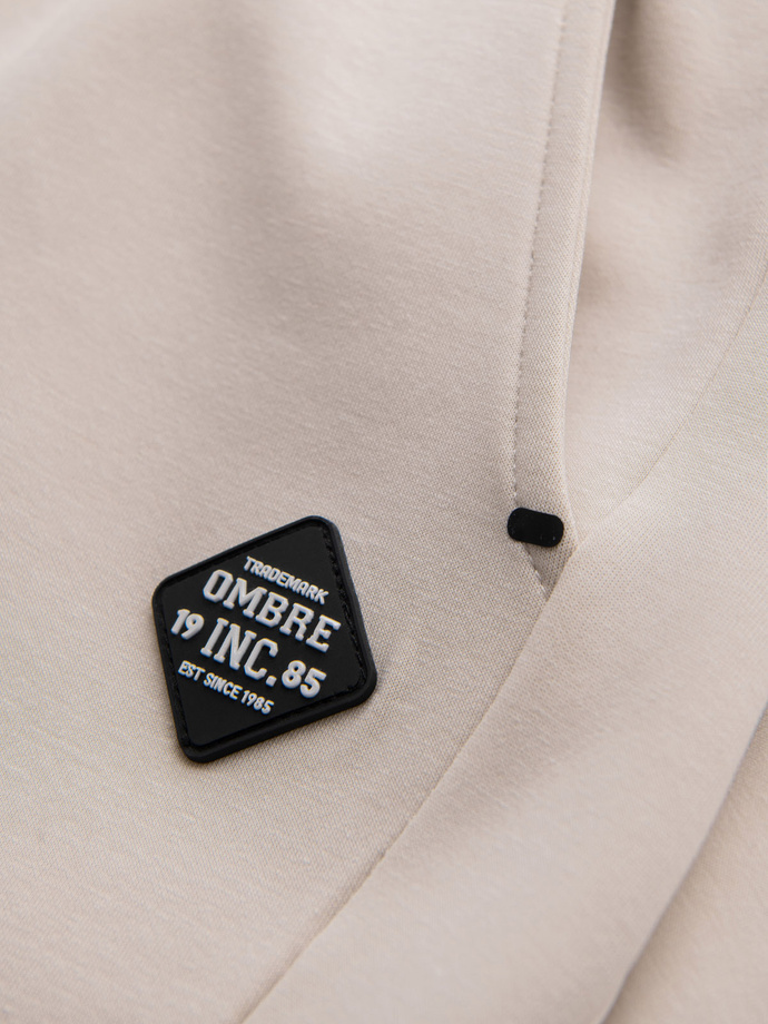 Męskie spodnie dresowe ze ściągaczami i ozdobnym zamkiem – piaskowe V6 OM-PASK-0226