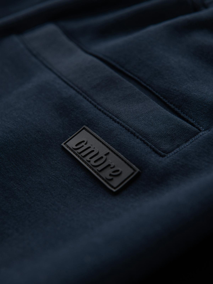 Spodnie męskie dresowe z prostą nogawką i gumowymi detalami – ciemnoniebieskie V2 OM-PASK-0281