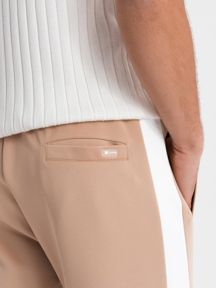 Męskie dresowe spodnie joggery z kontrastowymi lampasami – beżowe V4 OM-PASK-0229