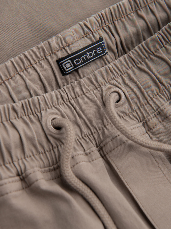 Męskie spodnie JOGGERY z zapinanymi kieszeniami cargo - beżowe V2 OM-PAJO-0123